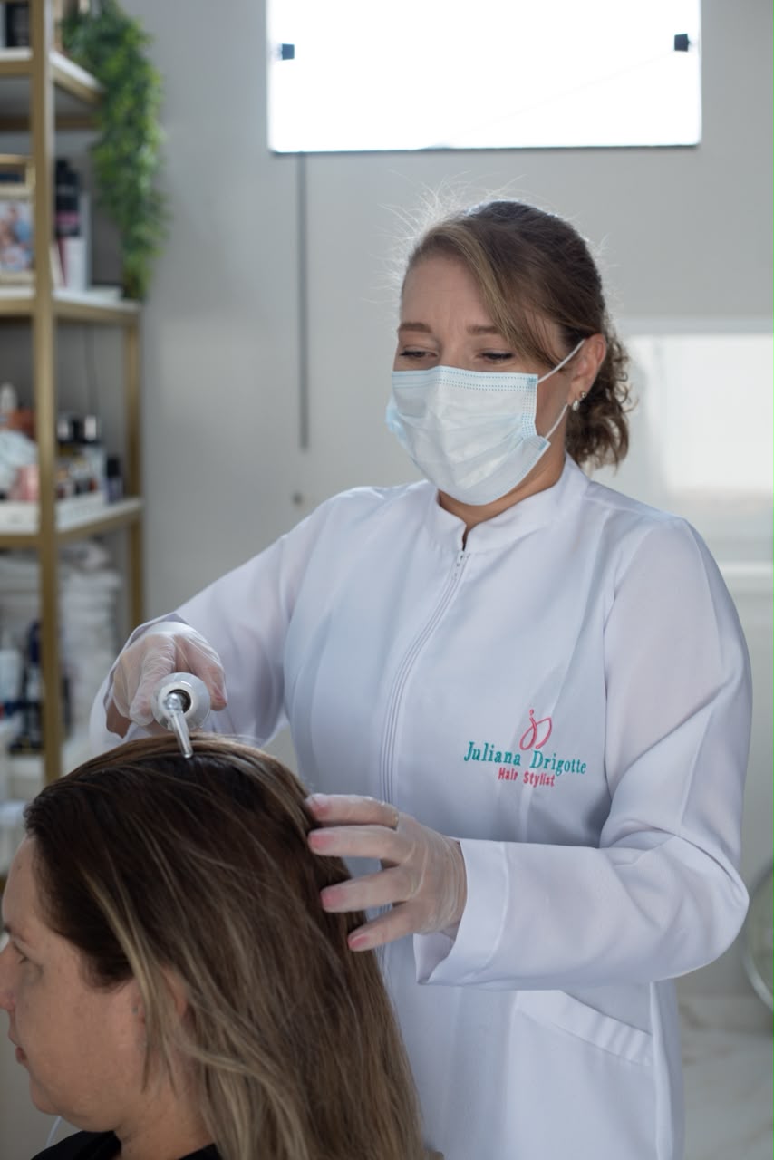 Juliana Terapeuta Capilar aplicando procedimento no couro cabeludo
